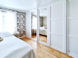 Makuuhuoneen valkoinen liukuovikaappi